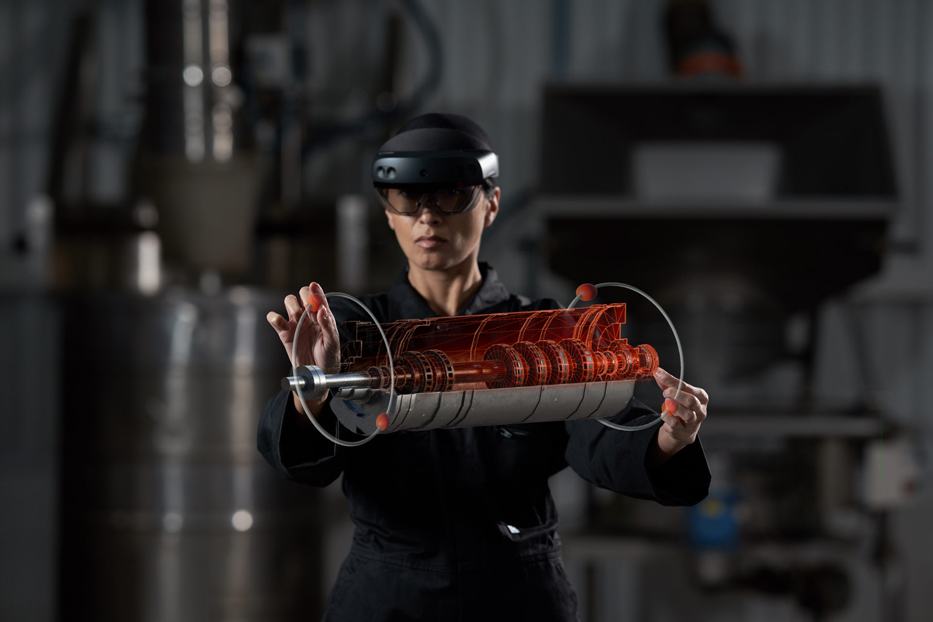 woman in a factory wearing a mixed reality headset and training on mechanical parts